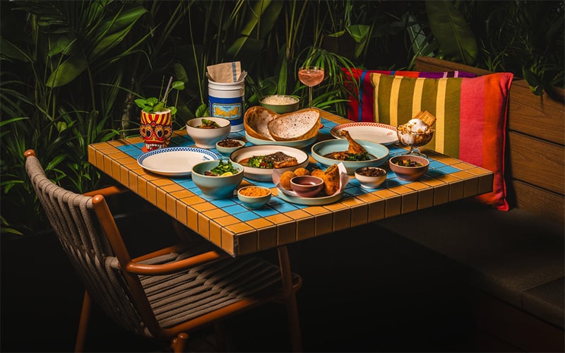 colorful table setting with assorted dishes on blue tiles