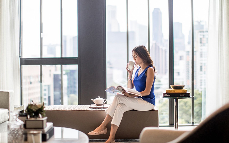 Business woman relaxing with drinks at a hotel lounge.